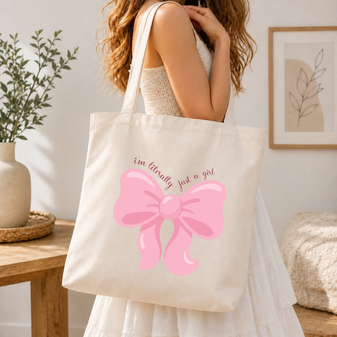 Person in a white dress carrying a canvas tote bag printed with the large pink bow graphic.
