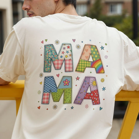 Person wearing a white t-shirt with colorful 'MAMA' text design.