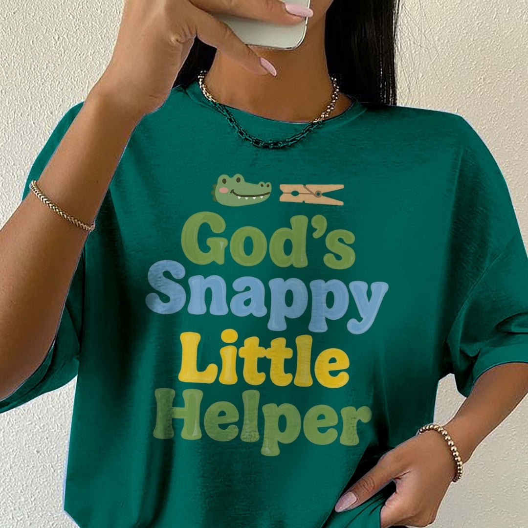 Person wearing a green t-shirt with 'God's Snappy Little Helper' text and graphic.