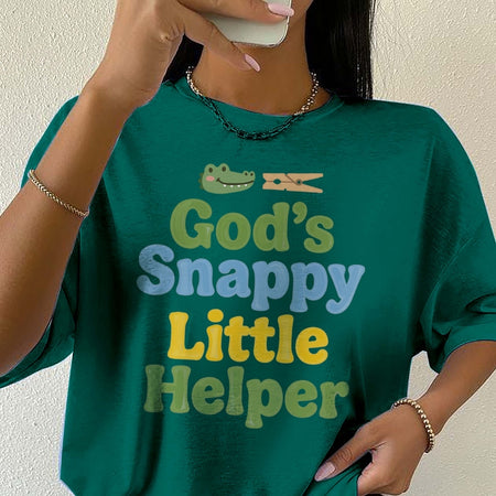 Person wearing a green t-shirt with 'God's Snappy Little Helper' text and graphic.