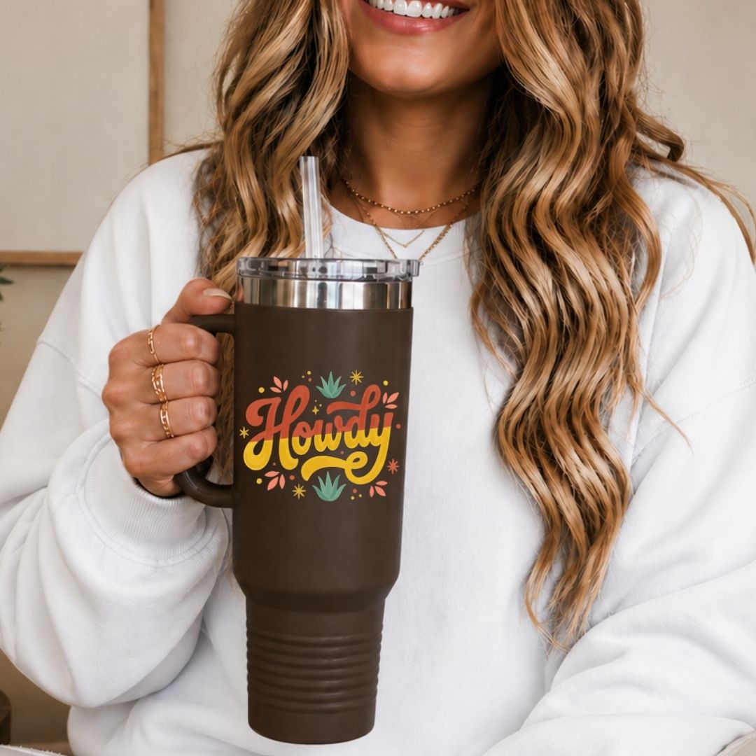 A woman holding a large brown travel tumbler with a handle, featuring the vintage "Howdy" desert script digital design asset.