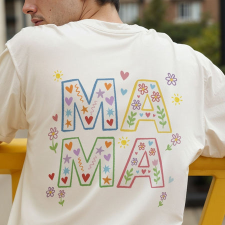 Person wearing a white t-shirt with colorful 'MAMA' design on the back.