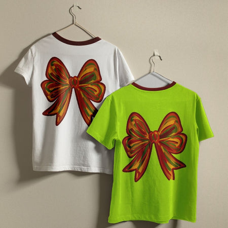 White and green t-shirts with a red and yellow butterfly design on a beige background