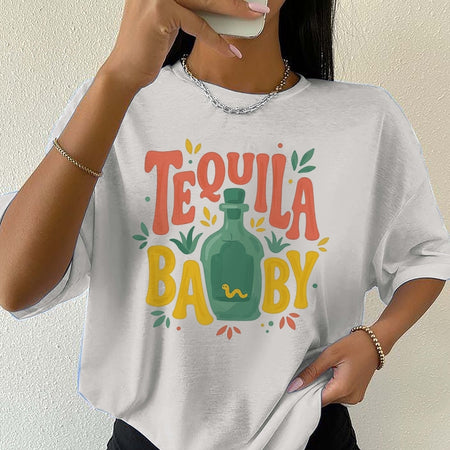 Person wearing a white t-shirt with 'Tequila Baby' design against a plain background
