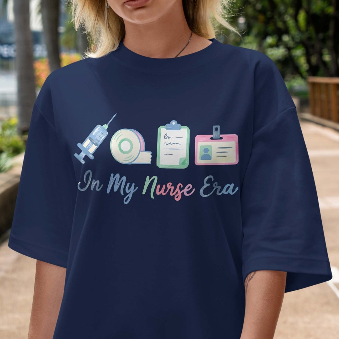 Person wearing a navy blue t-shirt with a nurse-themed design and text.