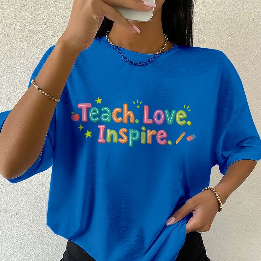 Person wearing a blue t-shirt with 'Teach. Love. Inspire.' text.