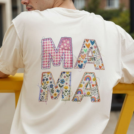 Person wearing a white t-shirt with colorful 'MAMA' text design.