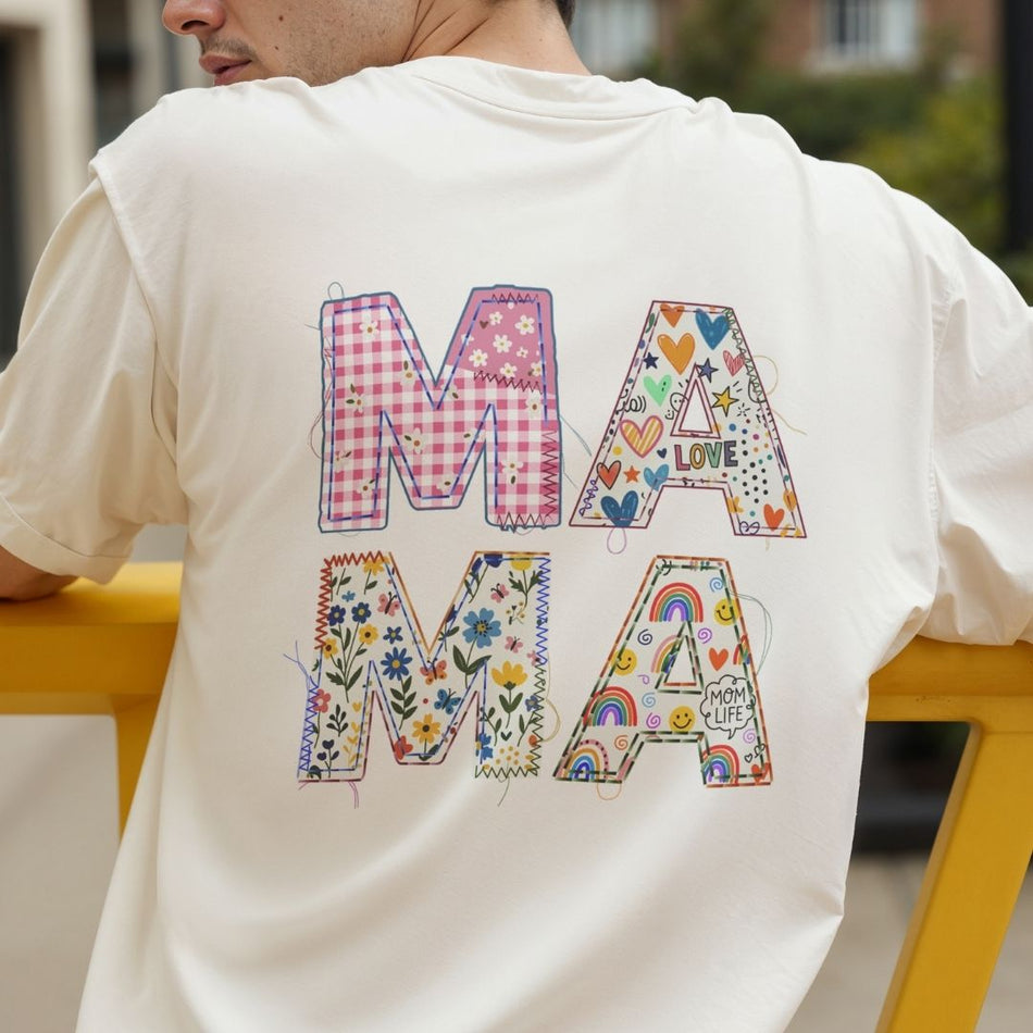 Person wearing a white t-shirt with colorful 'MAMA' text design.