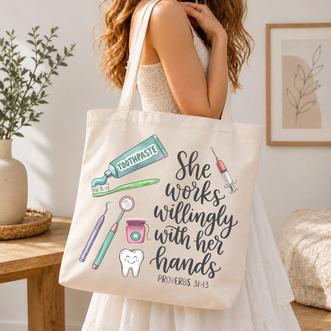 A woman wearing a white dress carries a cream canvas tote bag with a tooth-themed graphic and the quote 'She works willingly with her hands' from Proverbs 3:13. The tote bag features illustrations of a toothpaste tube, toothbrush, syringe, dental tools, a tooth, and a smiling tooth.
