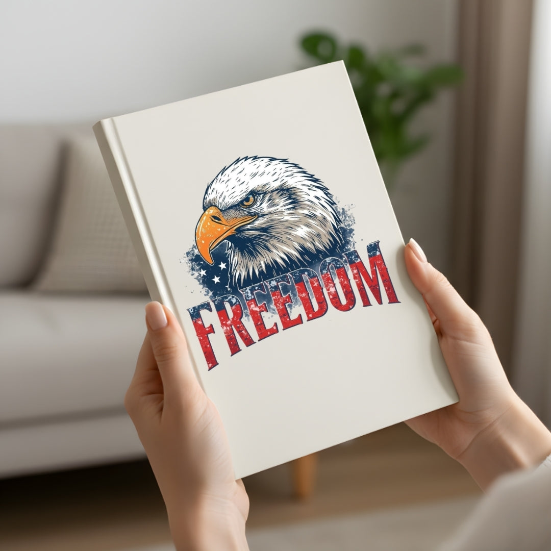 Book with an eagle and 'Freedom' text held by hands in a room.