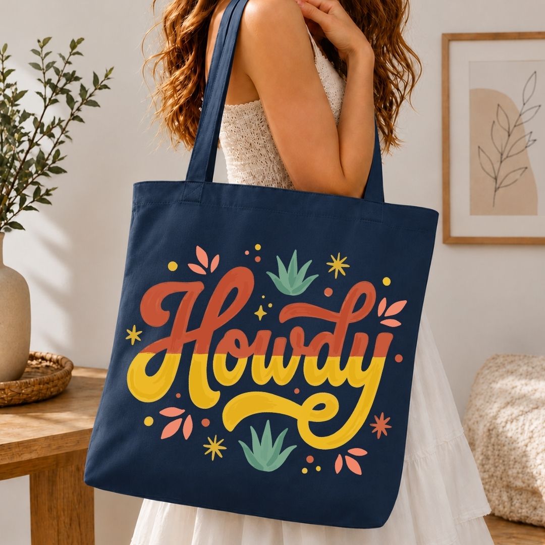 A woman carrying a dark navy blue canvas tote bag over her shoulder printed with a large, vibrant yellow and red "Howdy" logo.