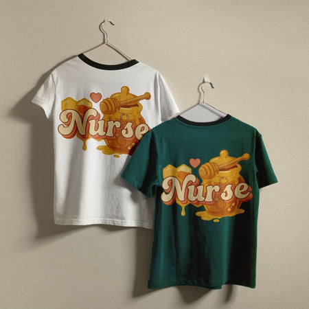 Two t-shirts with 'Nurse' design on hangers against a beige wall.