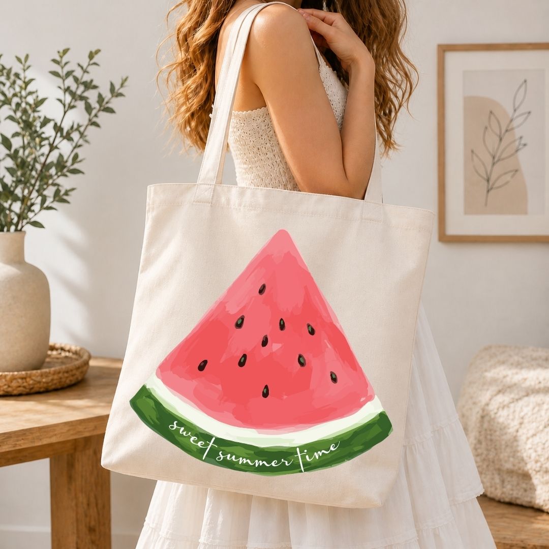 A woman carrying a cream-colored canvas tote bag over her shoulder, printed with a large, bright watercolor fruit graphic.