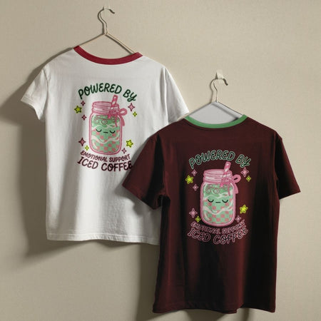 Two t-shirts with a design of a jar with a straw and text on a beige background