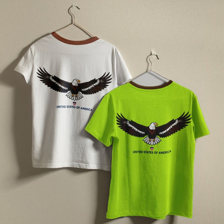 Two t-shirts with an eagle design on a beige background
