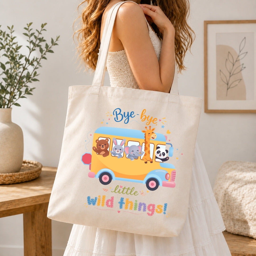 Person holding a tote bag with a colorful design of animals on a bus and text.