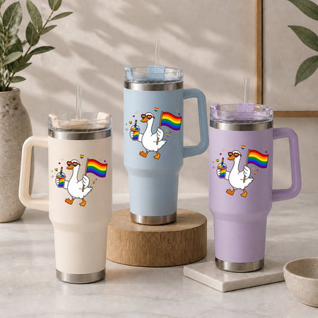 Three insulated travel mugs with cartoon geese and rainbow flags on a neutral background.