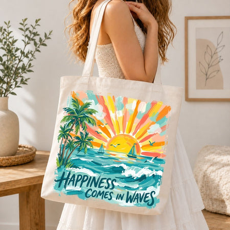 A woman wearing a white dress carries a cream canvas tote bag with a colorful tropical sunset and palm tree illustration. The bag features the text 'HAPPINESS COMES IN WAVES' in dark teal lettering.