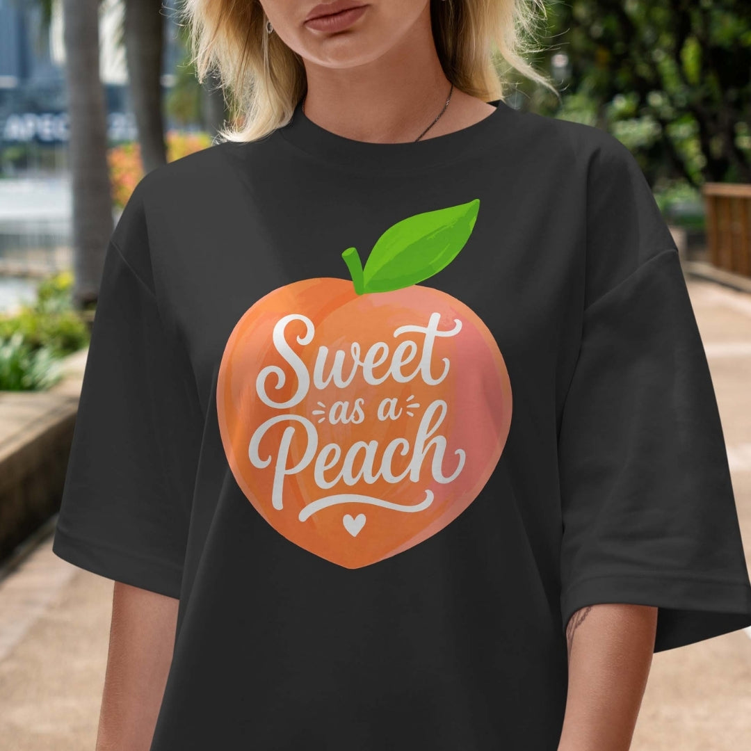 Person wearing a black t-shirt with a peach graphic and 'Sweet as a Peach' text.