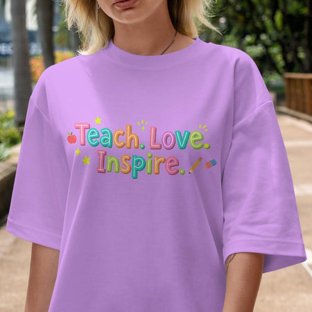 Person wearing a purple t-shirt with 'Teach. Love. Inspire.' text in colorful letters.