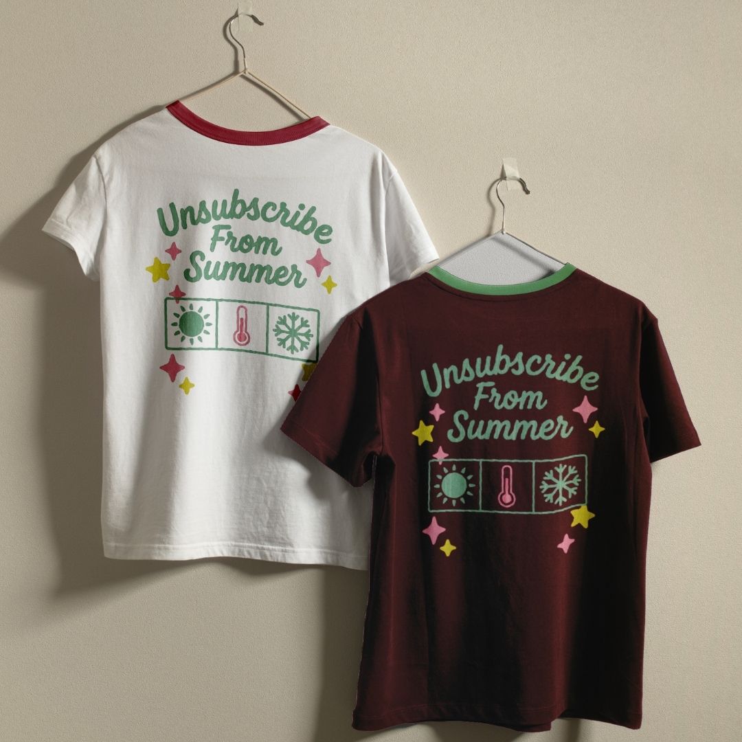 Two t-shirts with 'Unsubscribe From Summer' design on hangers against a beige wall.