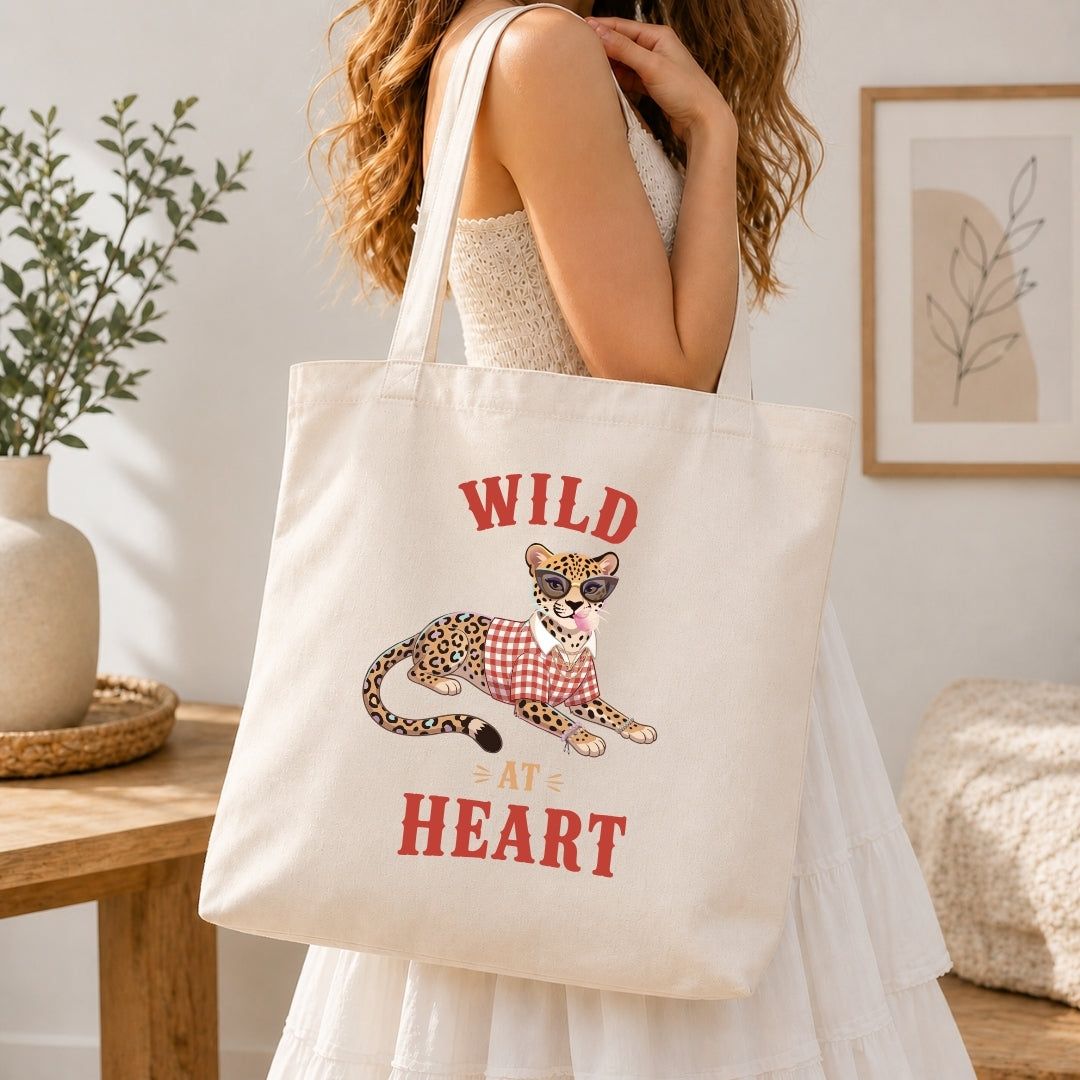 Hand holding a white ceramic coffee mug printed with the cool "Wild At Heart" leopard blowing bubblegum graphic.