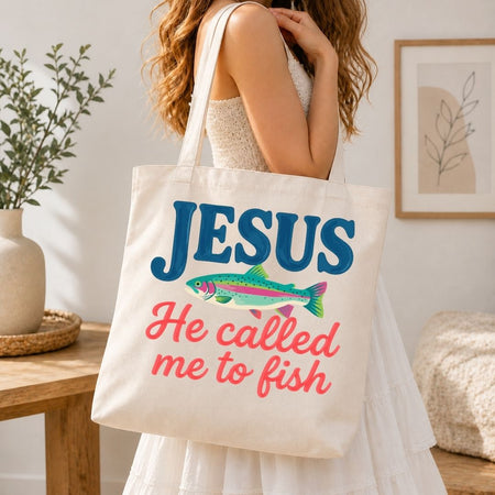 A woman carrying a cream-colored canvas tote bag over her shoulder printed with a large, vibrant "Jesus He Called Me to Fish" logo.