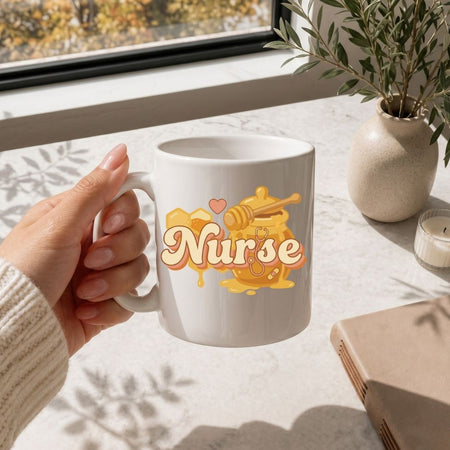 White mug with 'Nurse' design held by a hand on a light surface with a window and plant in the background.