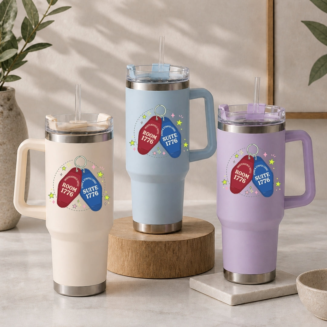 Three insulated travel mugs with decorative tags on a neutral background