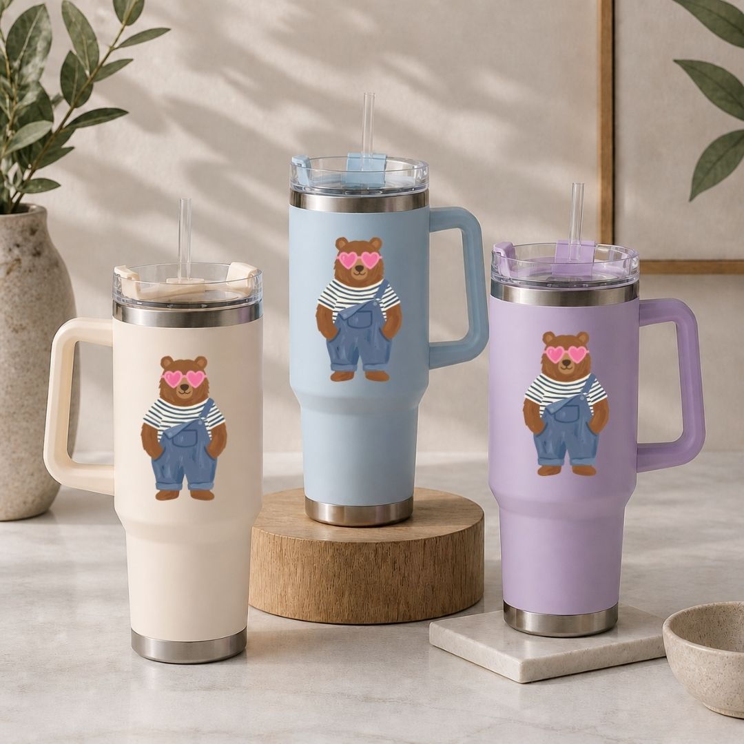 Three insulated mugs with bear illustrations on a neutral background