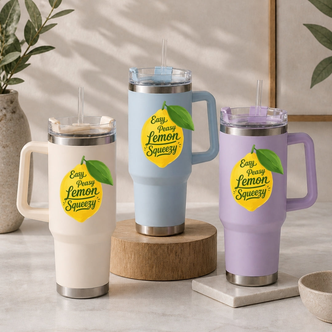 Three insulated travel mugs with lemon-themed design on a neutral background
