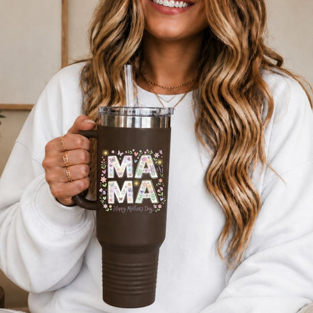 Person holding a brown mug with 'MAMA' and flowers design, smiling.