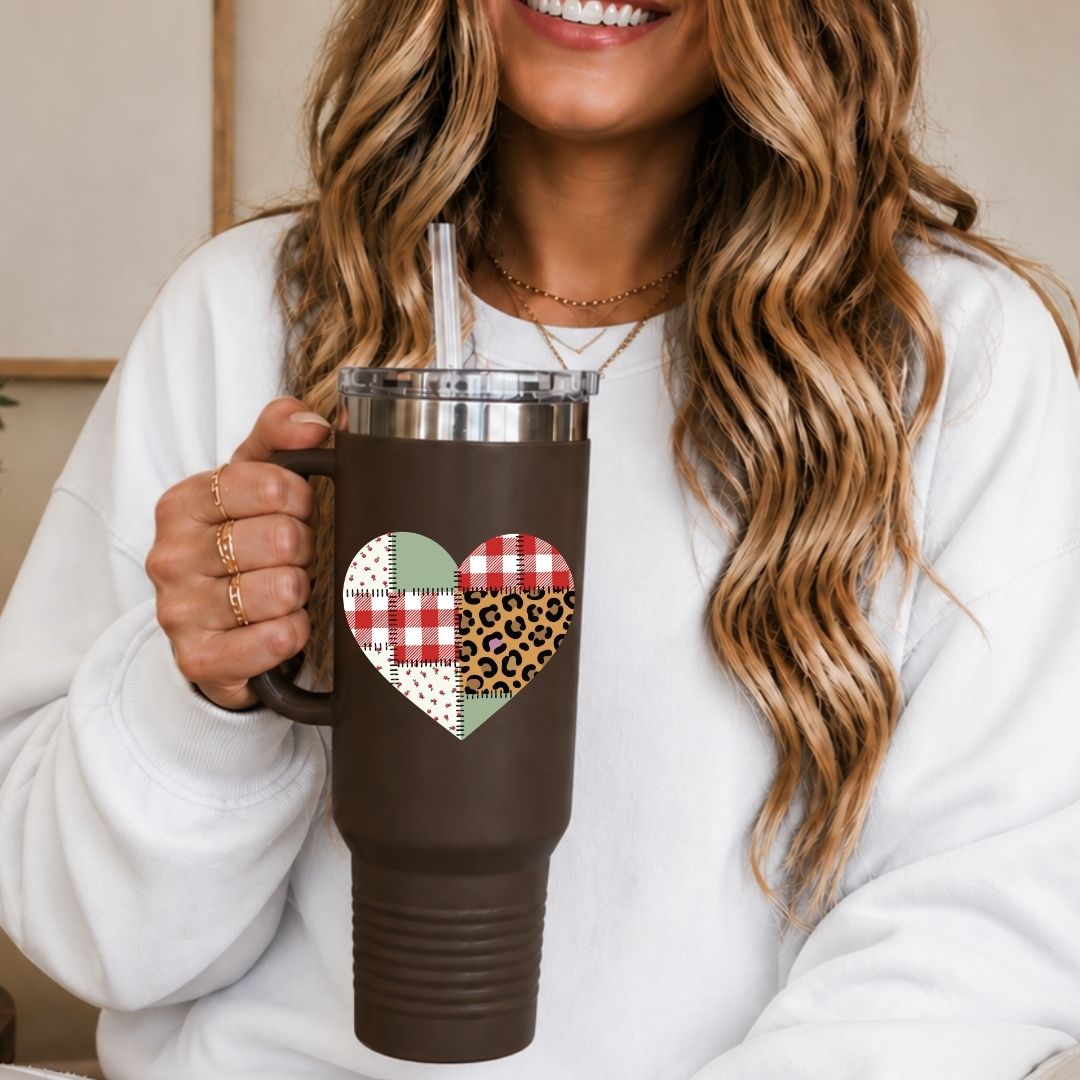 Person holding a brown mug with a heart-shaped pattern, smiling.