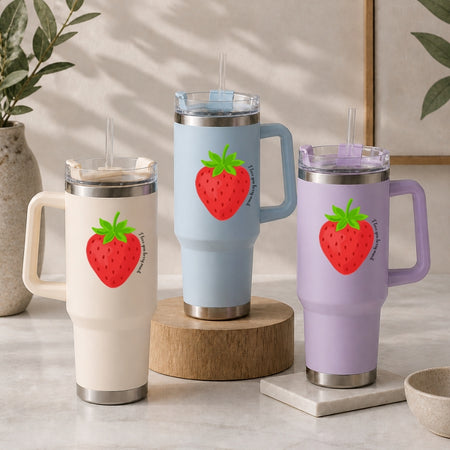 Three insulated travel mugs with strawberry design on a neutral background
