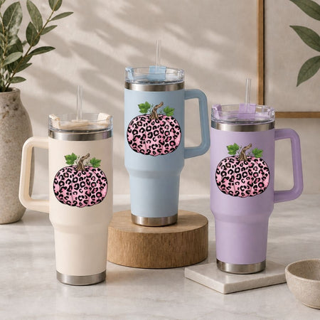 Three insulated mugs with leopard print pumpkins on a neutral background