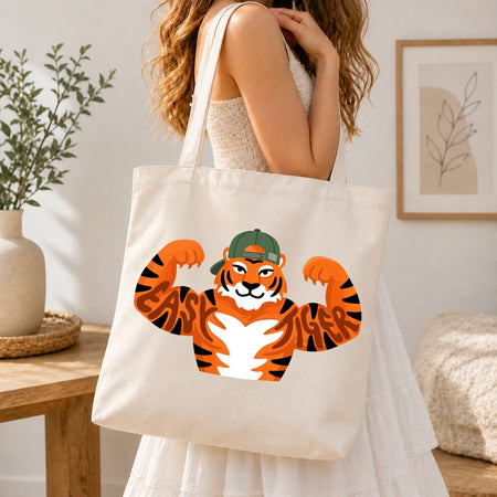 Person holding a tote bag with a tiger design in a home setting
