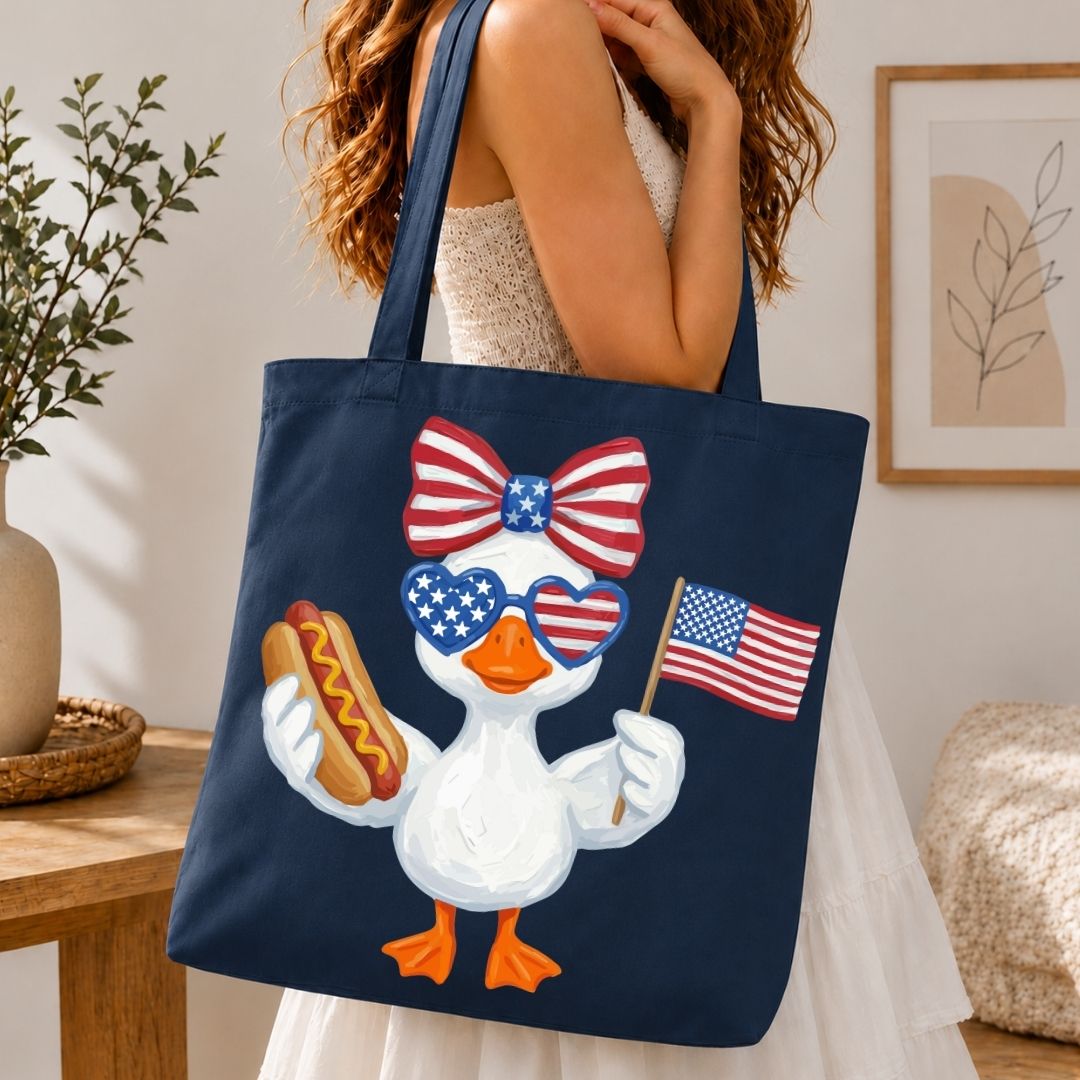 Navy tote bag with a patriotic duck design held by a person in a room.