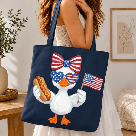 Navy tote bag with a patriotic duck design held by a person in a room.