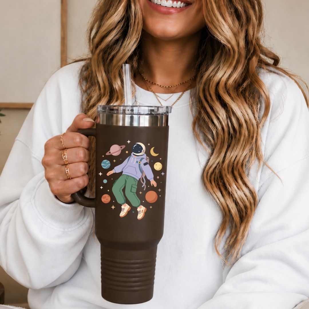 Person holding a brown mug with space-themed design