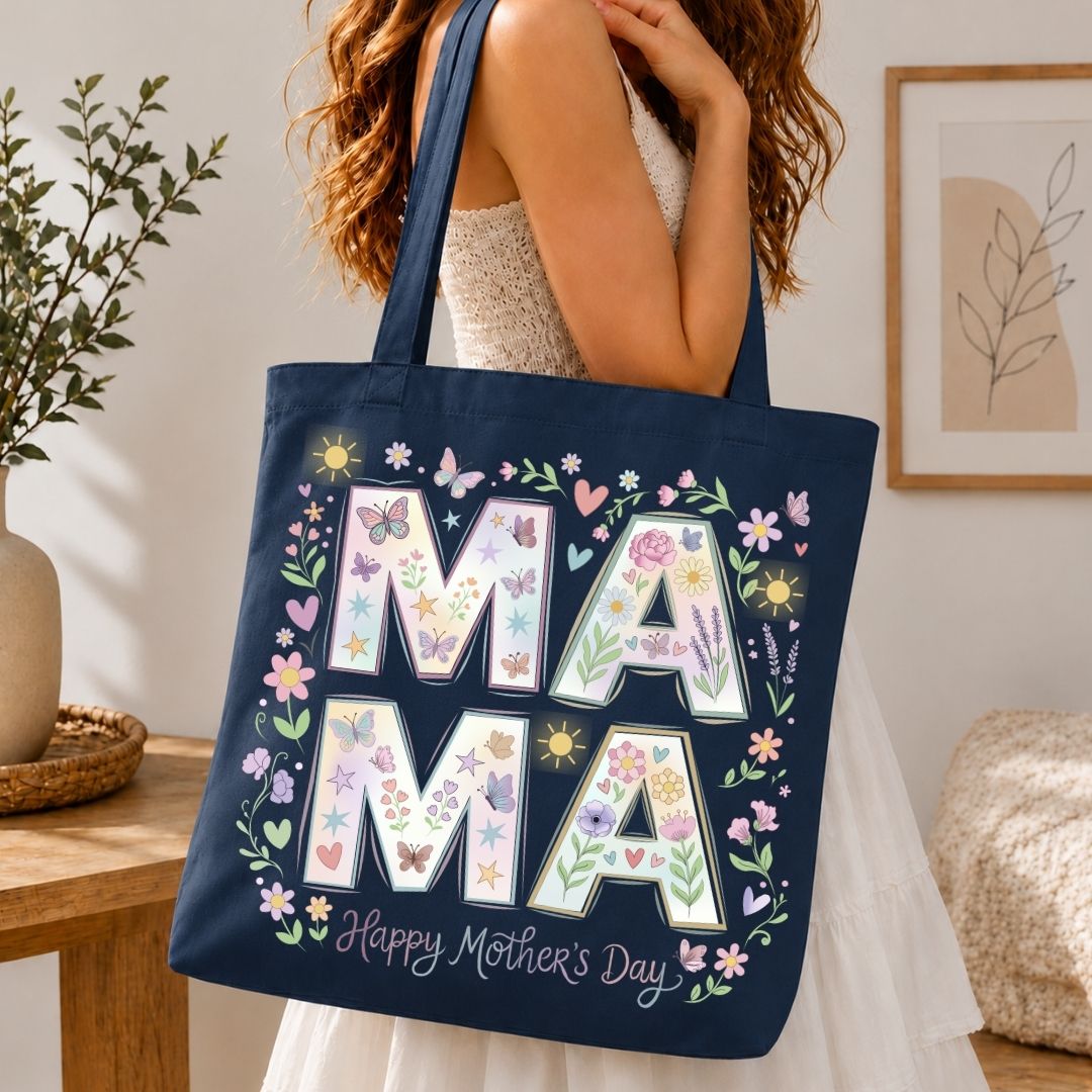 Navy tote bag with floral 'MAMA' design held by a person in a home setting.