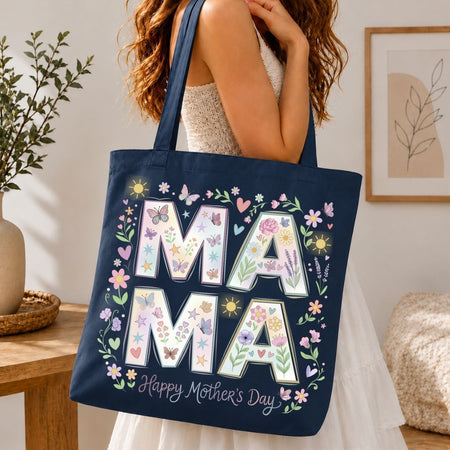 Navy tote bag with floral 'MAMA' design held by a person in a home setting.
