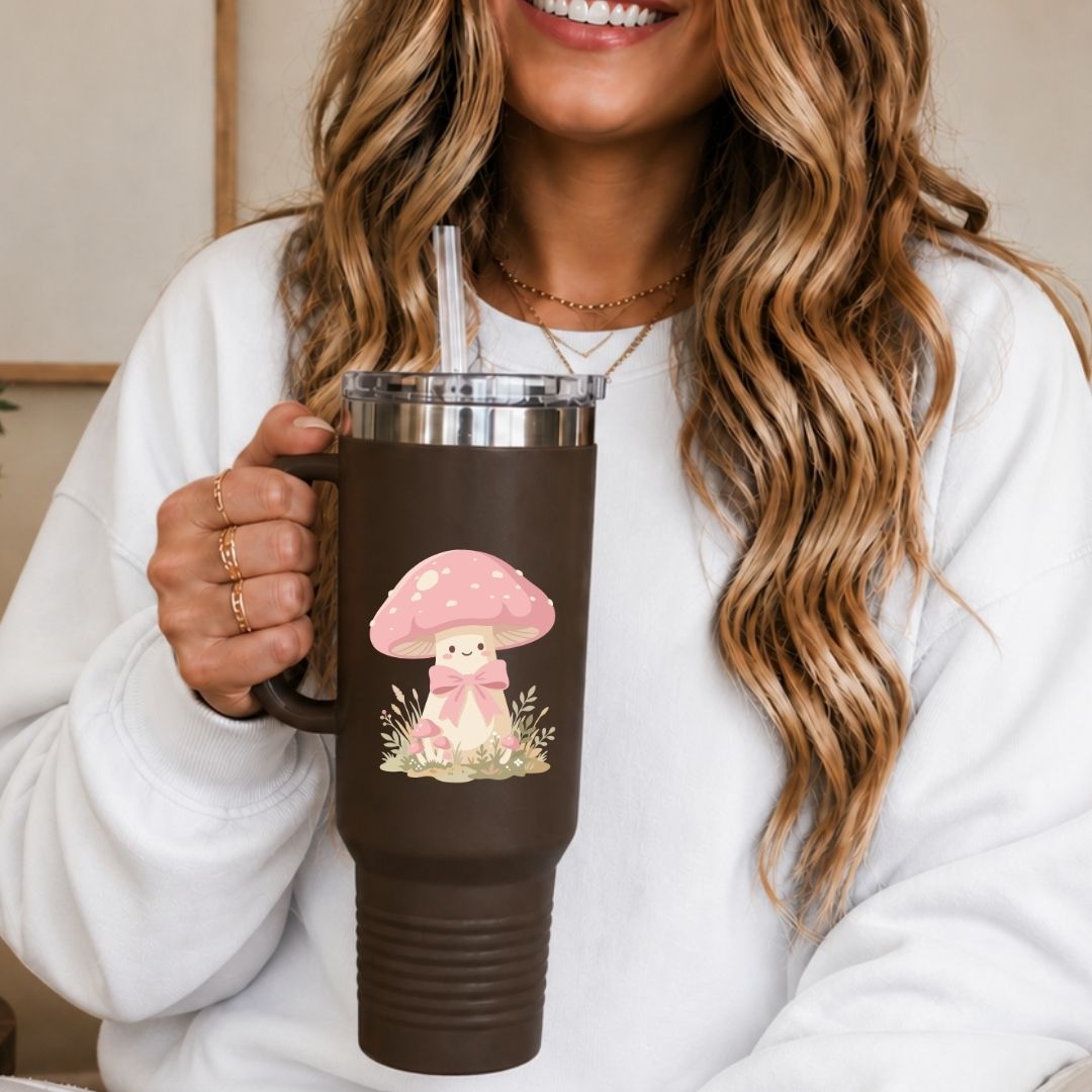 Person holding a brown mug with a pink mushroom design, wearing a white sweatshirt.