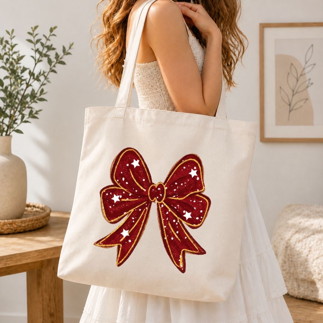 Person holding a tote bag with a red bow design in a home setting