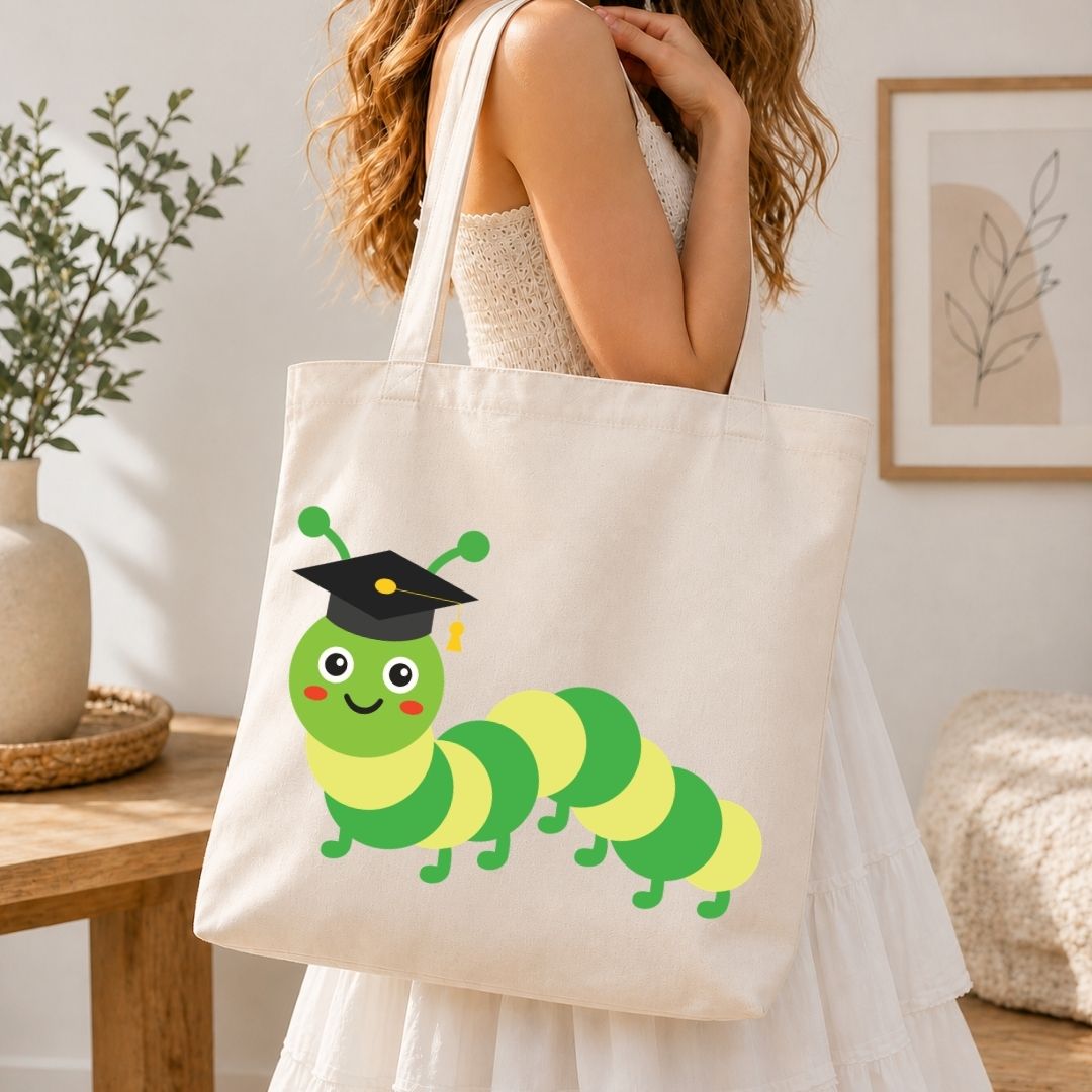 Person holding a tote bag with a cartoon caterpillar wearing a graduation cap.