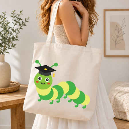 Person holding a tote bag with a cartoon caterpillar wearing a graduation cap.