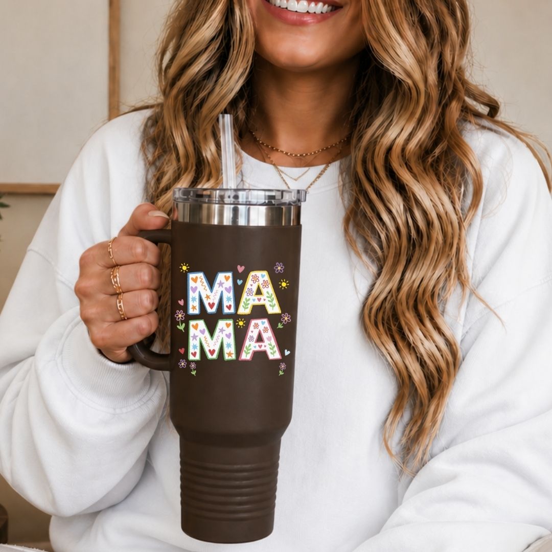 Person holding a brown mug with 'MAMA' in colorful letters