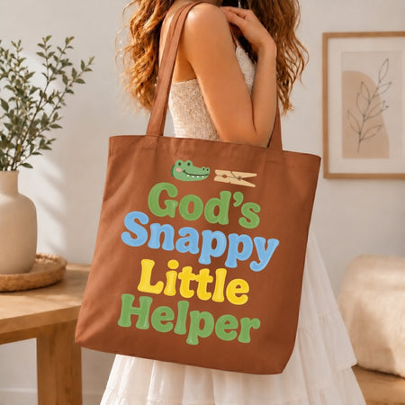 Person holding a brown tote bag with colorful text and graphics in a home setting.