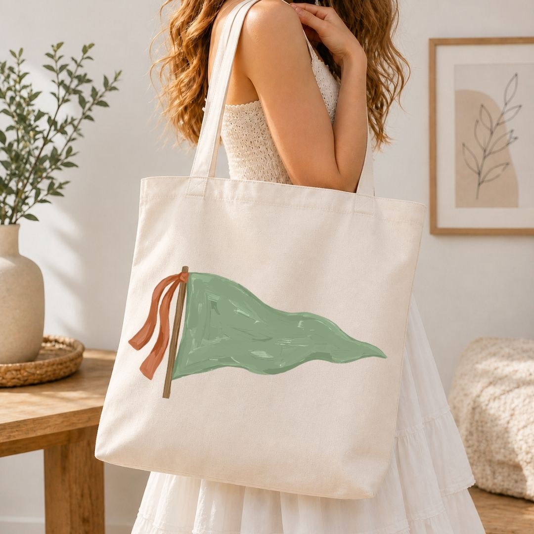 Person holding a tote bag with a green leaf design in a home setting