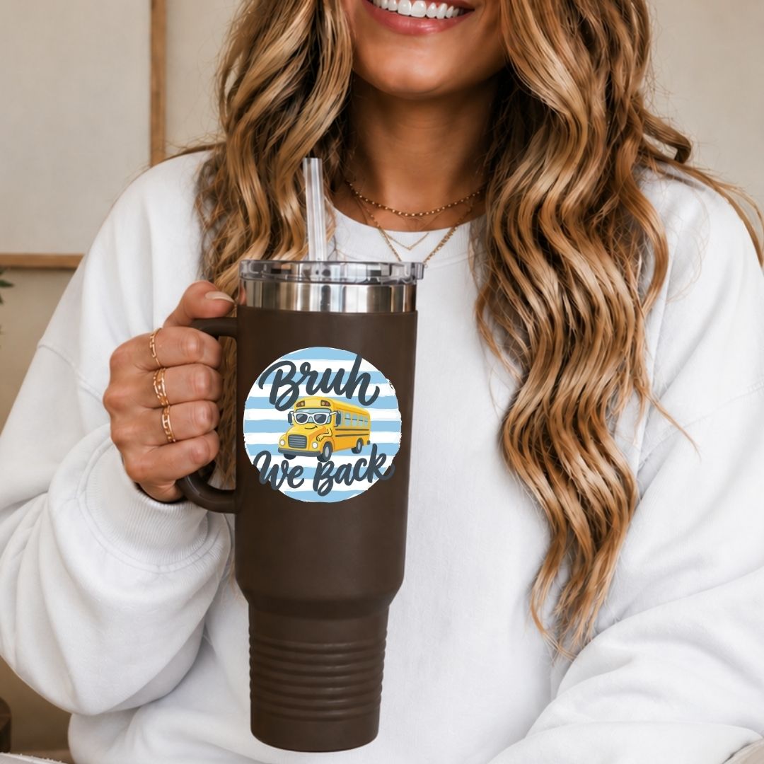 Person holding a brown tumbler with a 'Brush We Back' sticker, wearing a white sweatshirt.