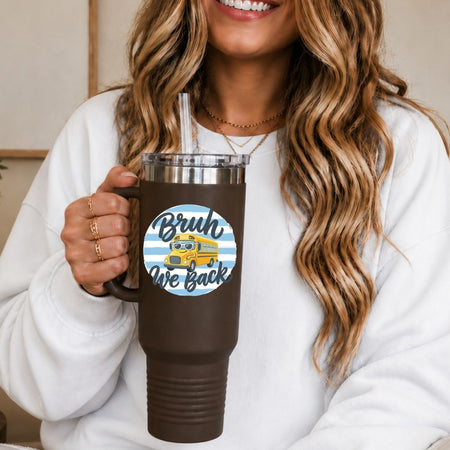 Person holding a brown tumbler with a 'Brush We Back' sticker, wearing a white sweatshirt.